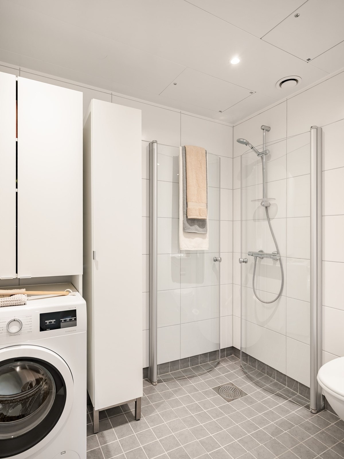 Badet er utstyrt med servant, dusjnisje, vegghengt toalett og opplegg for vaskemaskin. God plass til oppbevaring i skap. Galleribilde
