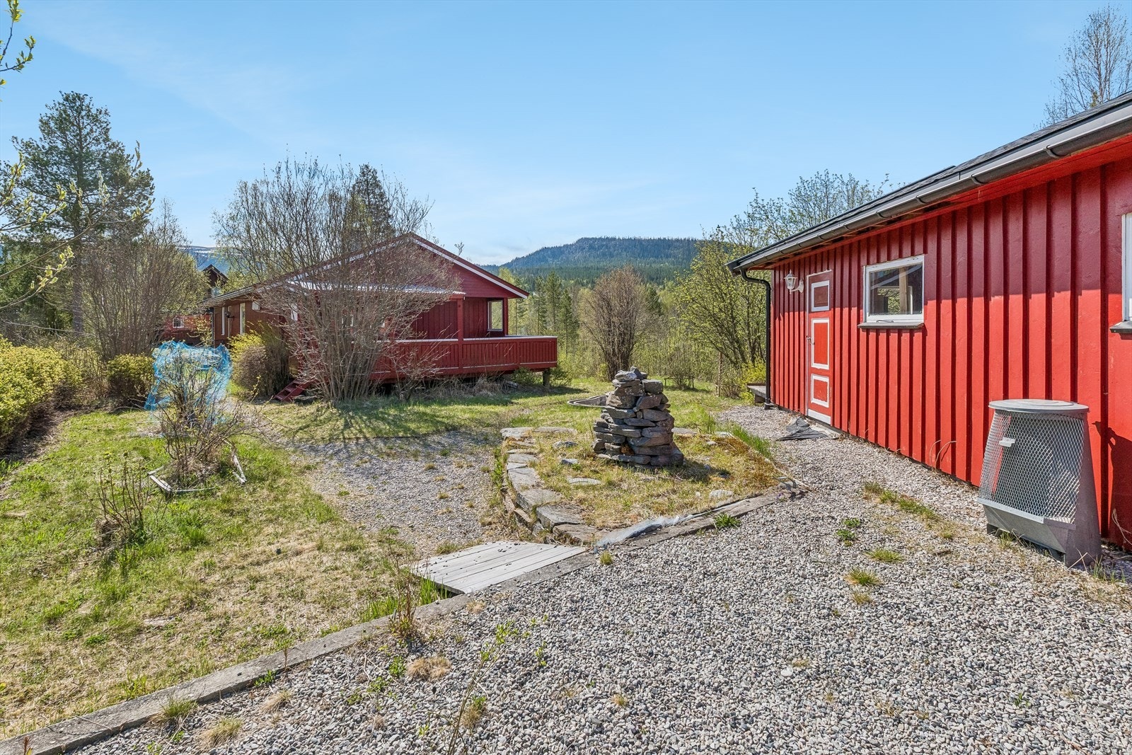 Tomten er flat og skrånet, opparbeidet med plen og busker. Innkjørselen er gruset. Galleribilde