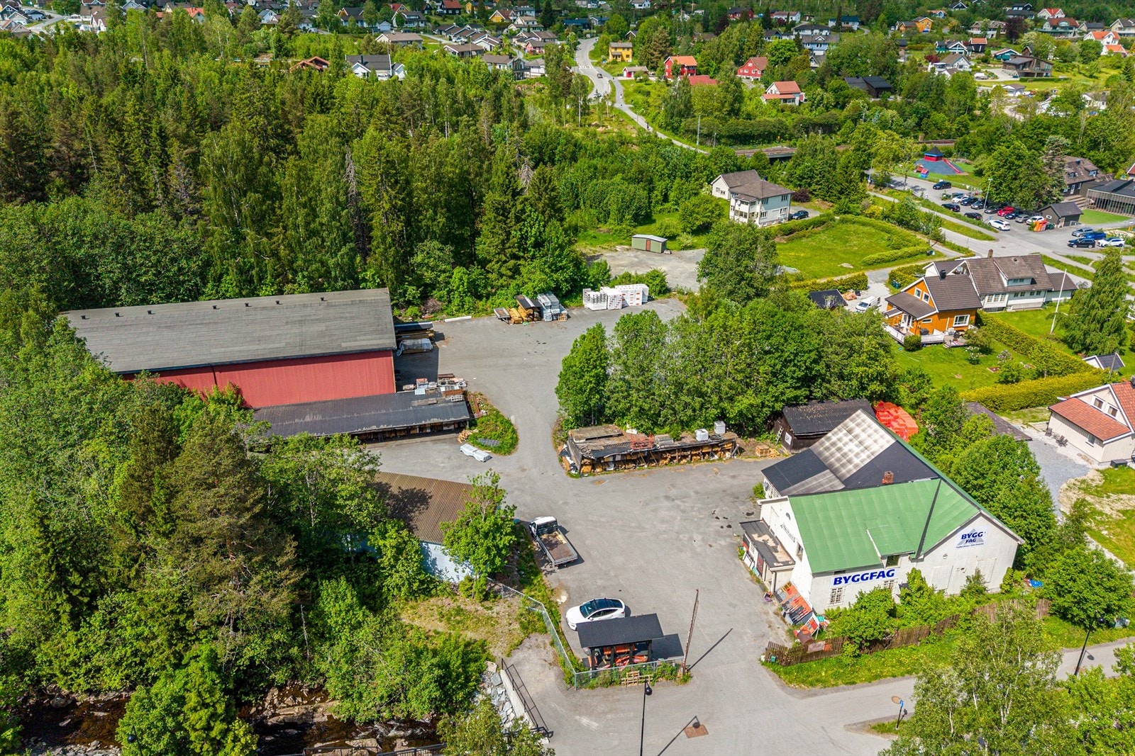 Oversikt over eiendommen med hovedbygget i front og de store lagerhallene og uteområdene i bakkant. Galleribilde