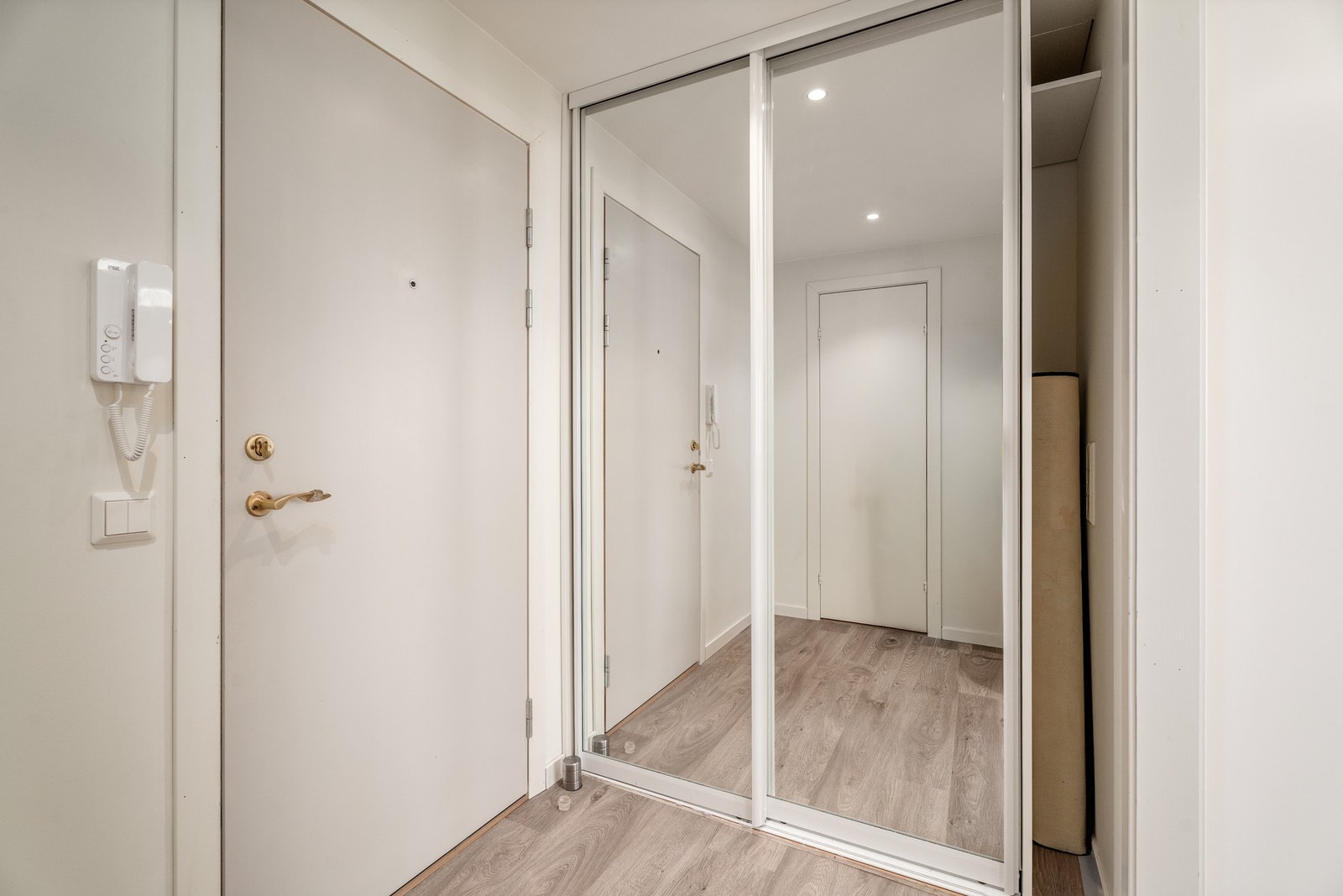 Romslig gang med portåpner til ytterdør og skyvedørsgarderobe. Galleribilde