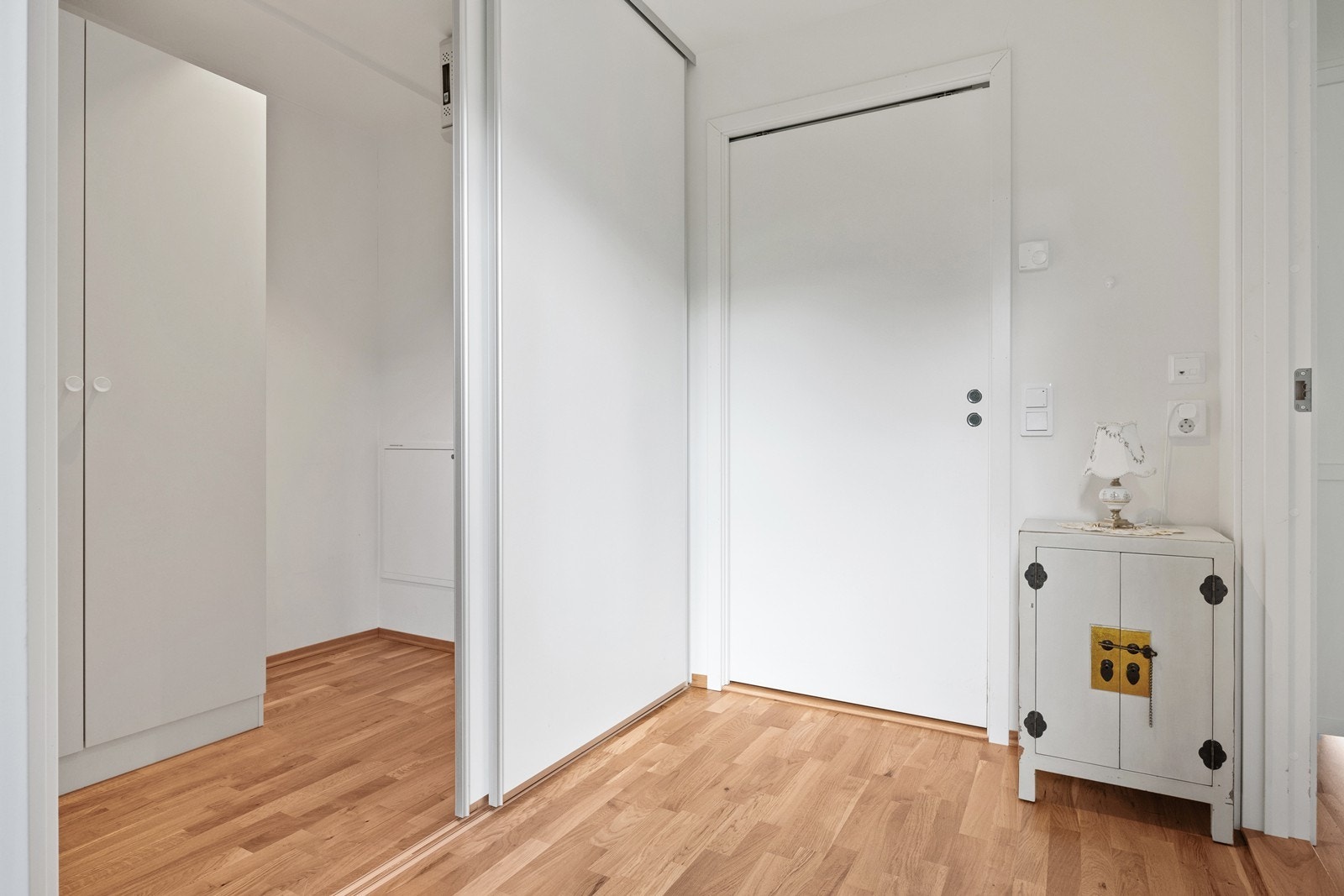 Lys gang med en stor skyvedørsgarderobe/bod. Galleribilde