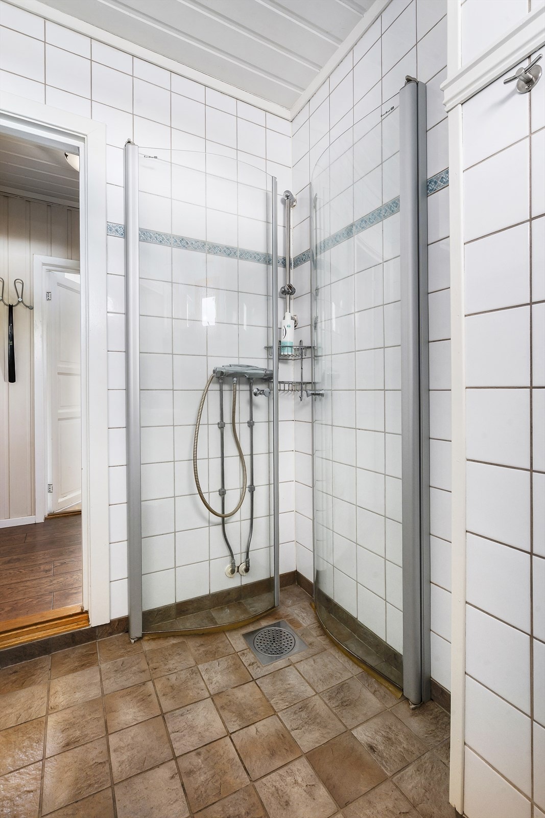Badet har flislagt gulv med elektriske varmekabler og dusjhjørne med innfellbare vegger. Galleribilde