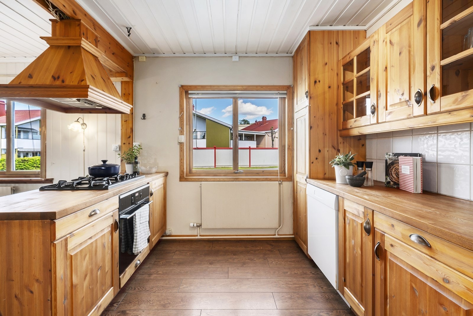 Kjøkkeninnredning med profilerte fronter i furu og fliser over benken. Galleribilde