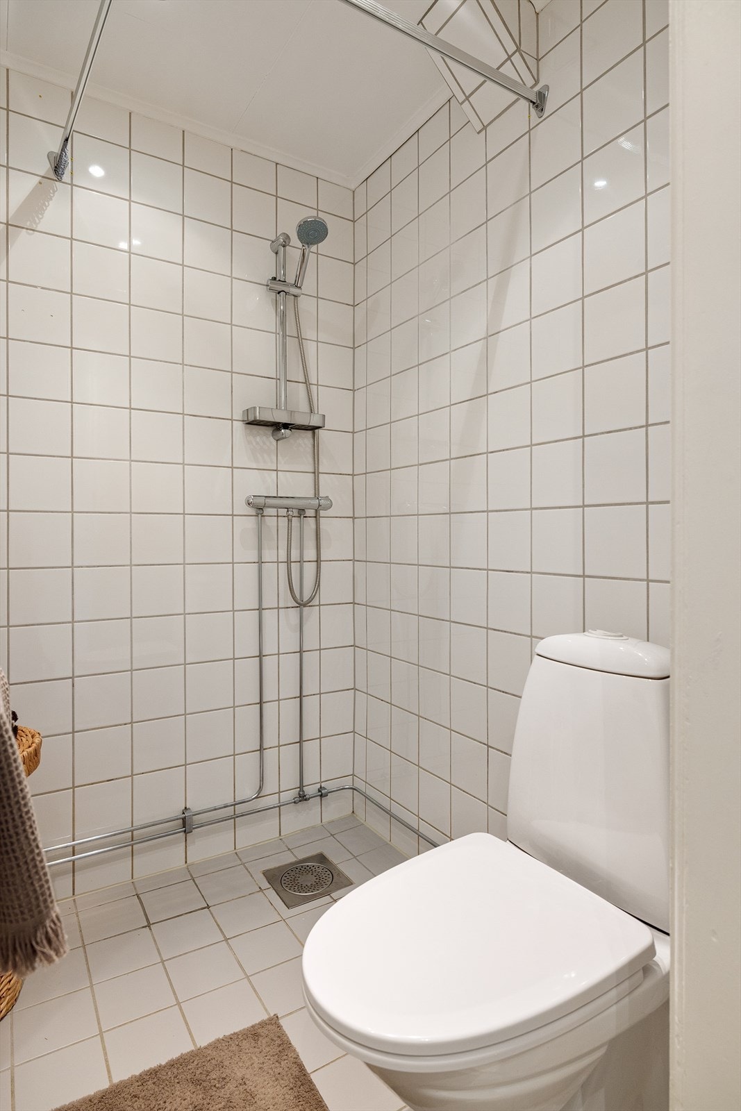 Innredning består av servant med underskap, speil, vegghengt skap, toalett og dusjsone. Galleribilde