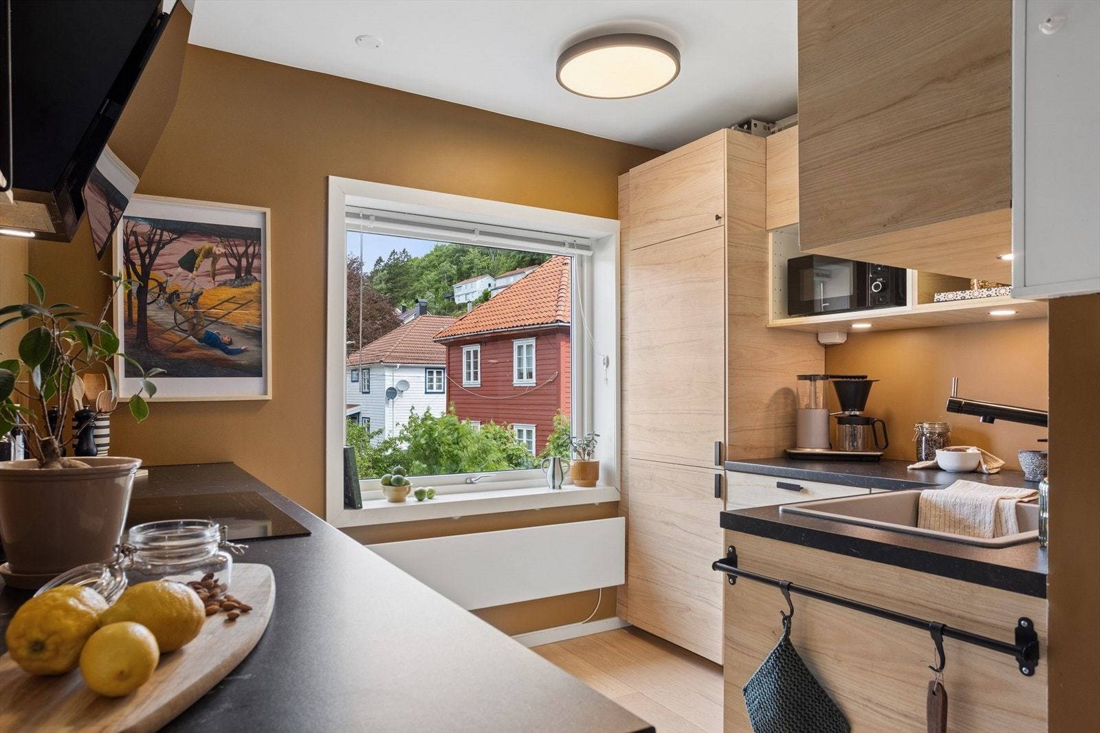 Kjøkken med glatte fronter, benkeplate av laminat og nedfelt vask og platetopp Galleribilde