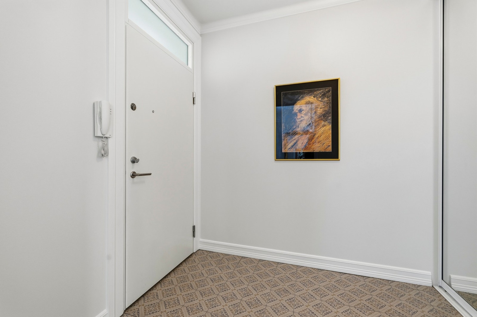 Entréen er innredet med en stor skyvedørsgarderobe med speilfronter som gir en praktisk løsning for oppbevaring av yttertøy og sko, og bidrar til et ryddig og funksjonelt inngangsparti. Galleribilde