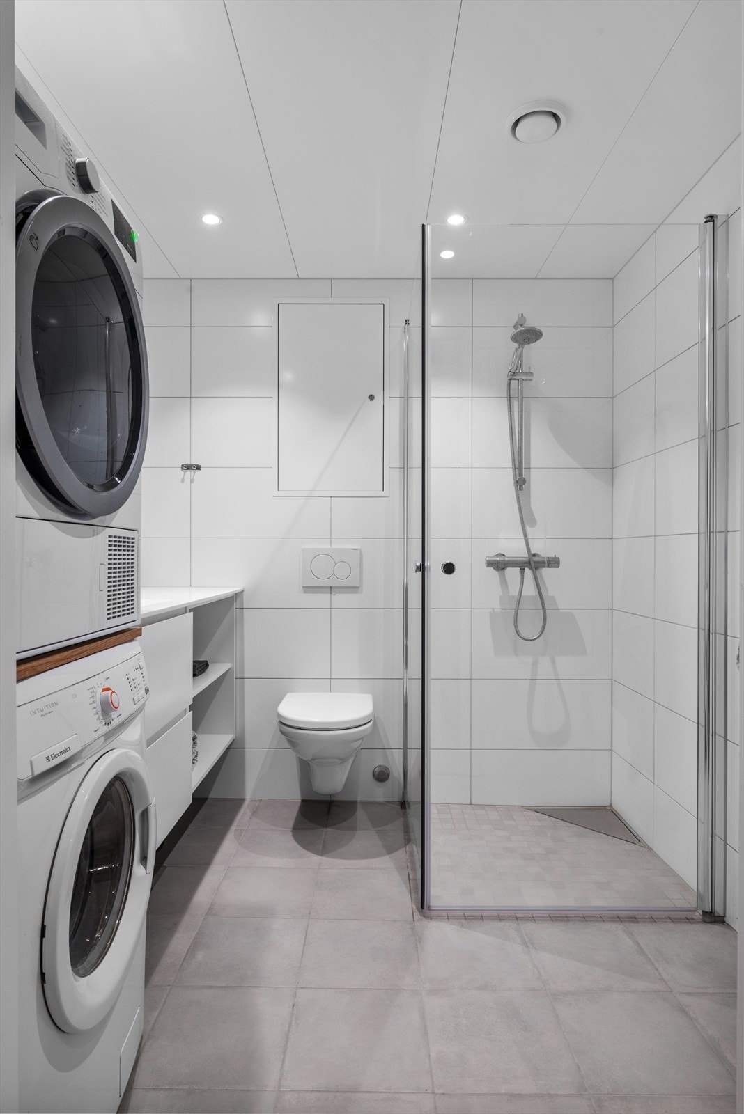 Det 4,5 m² store badet fremstår som innbydende med helflisede overflater, behagelig gulvvarme og downlights i tak. Galleribilde