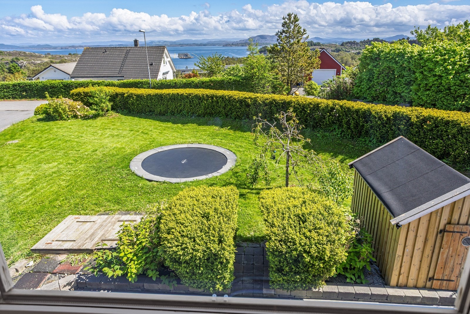 Flott utsikt ned i hagen og ut i fjorden fra tv-stuen i andre etasje. Galleribilde