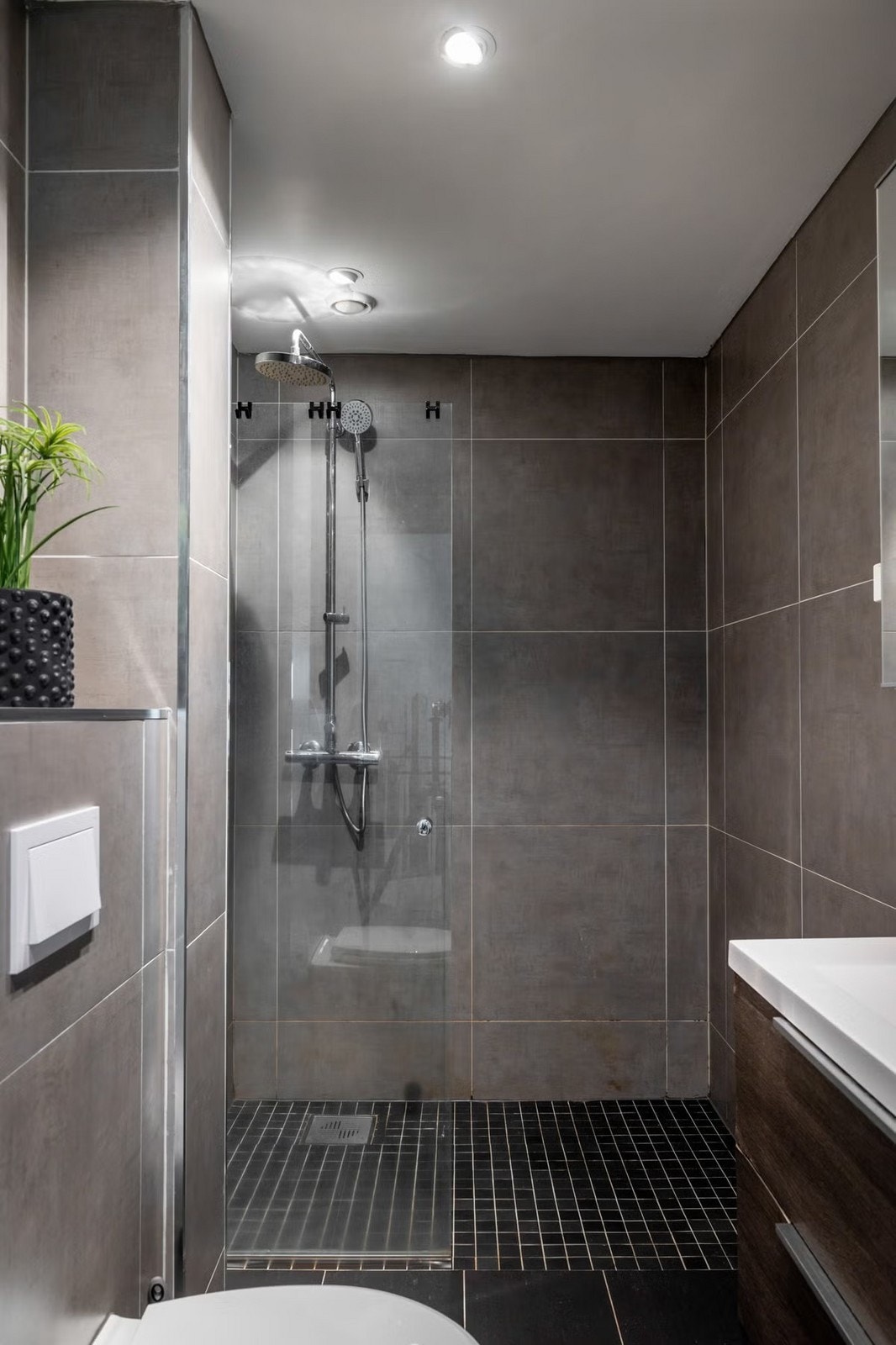 Badet er innredet med vegghengt toalett, servantinnredning m/ oppbevaring og dusjnisje m/ glassvegg Galleribilde