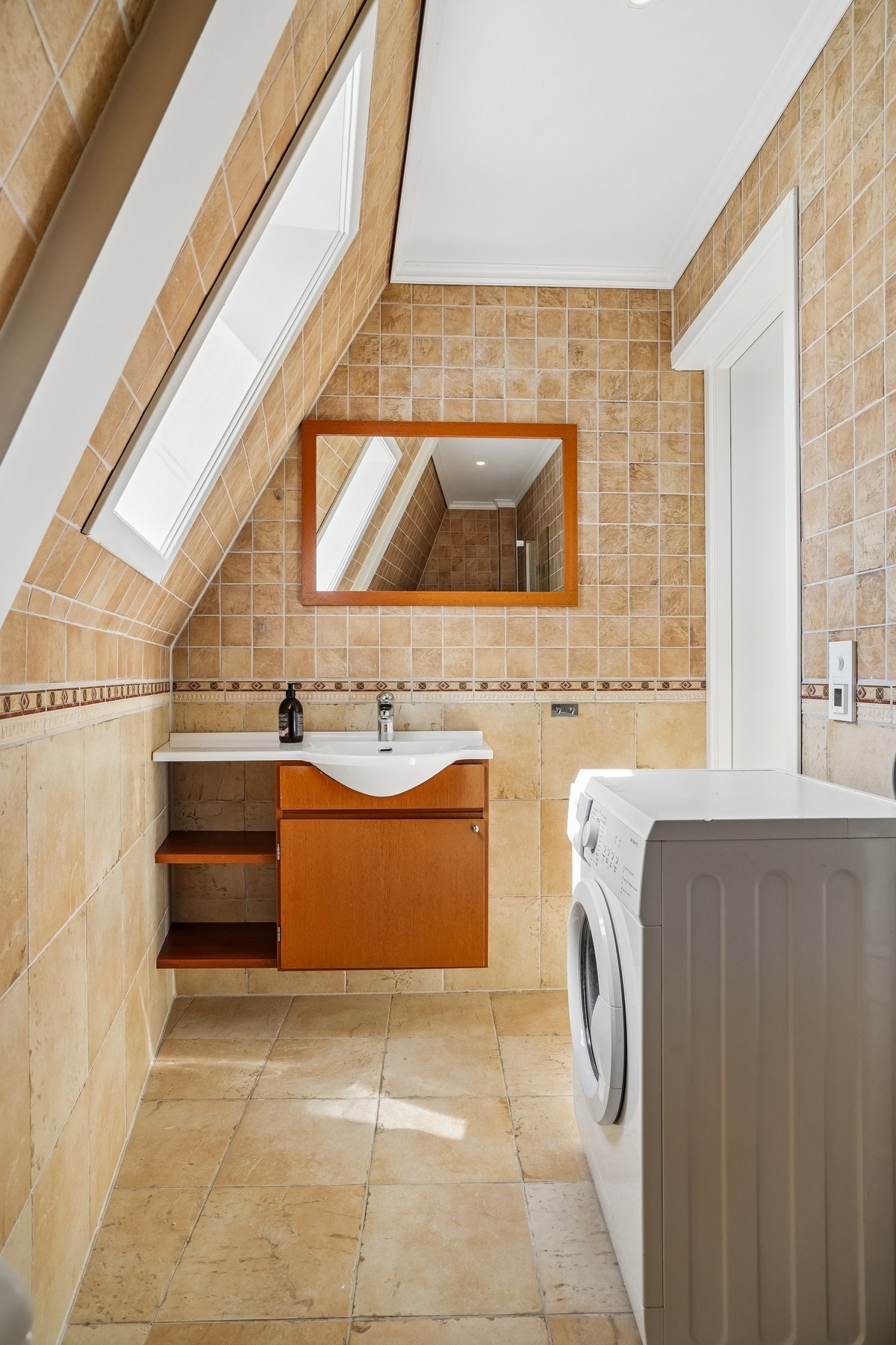 Badet er helfliset og har elektriske varmekabler i gulvet. Det ble montert ny termostat i 2019. Rommet kombineres med vaskerom og har opplegg for vaskemaskin - denne medfølger i handelen. Galleribilde