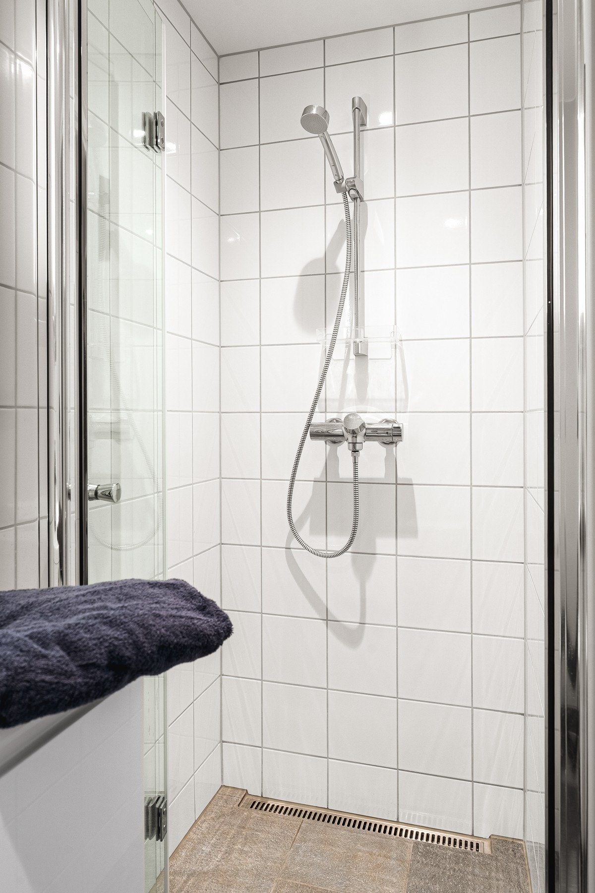 Badet er utstyrt med dusj, vegghengt toalett og servantinnredning. Galleribilde