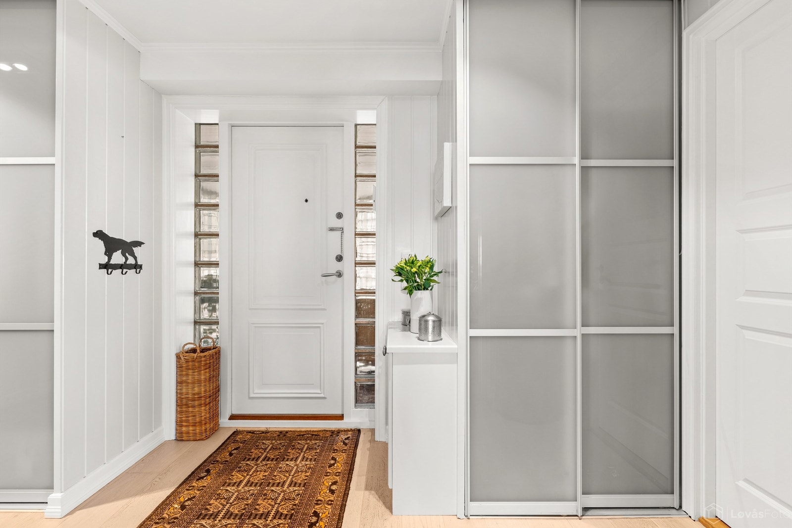 Romslig entré med gulvvarme og en stor skyvedørsgarderobe for effektiv oppbevaring av yttertøy. Galleribilde