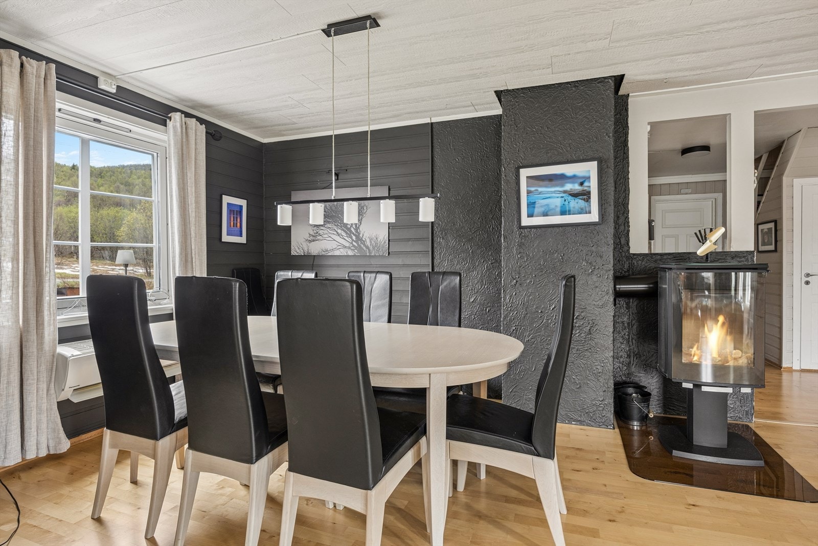 Stuen er utstyrt med en vedovn av nyere dato, som både gir effektiv oppvarming og tilfører rommet en varm og innbydende stemning. Perfekt for koselige kvelder året rundt. Galleribilde