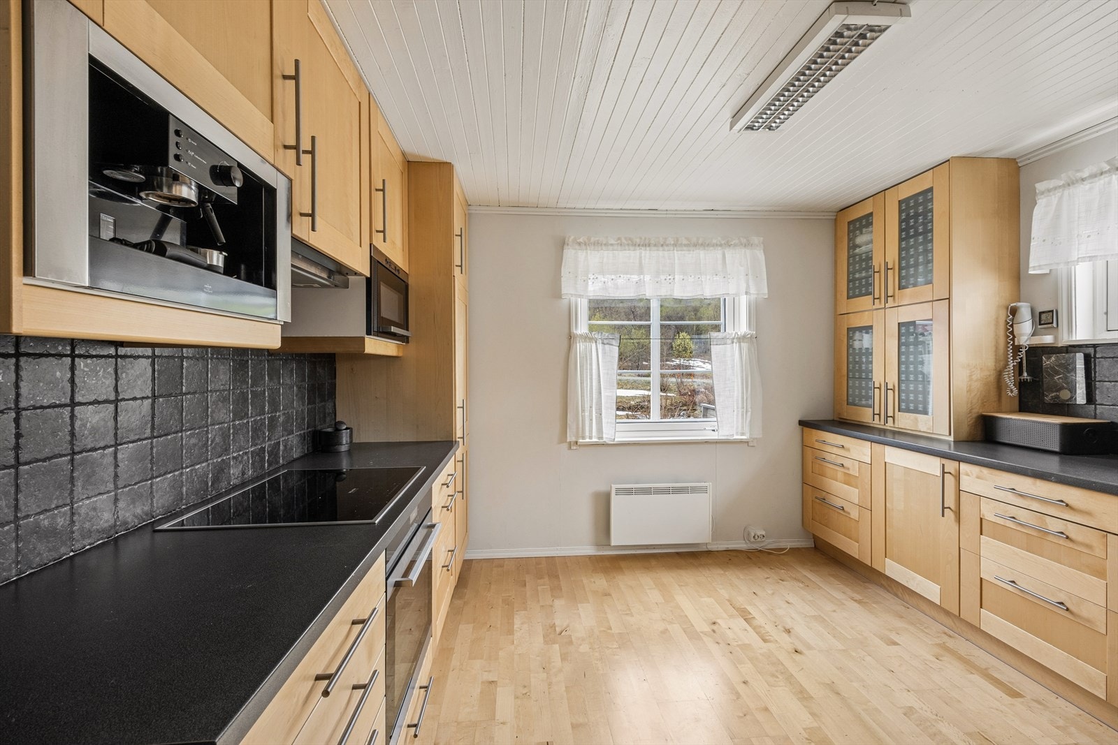 Kjøkkenet har innredning med fronter i bjørk og er utstyrt med kaffemaskin, stekeovn og induksjonstopp. Galleribilde