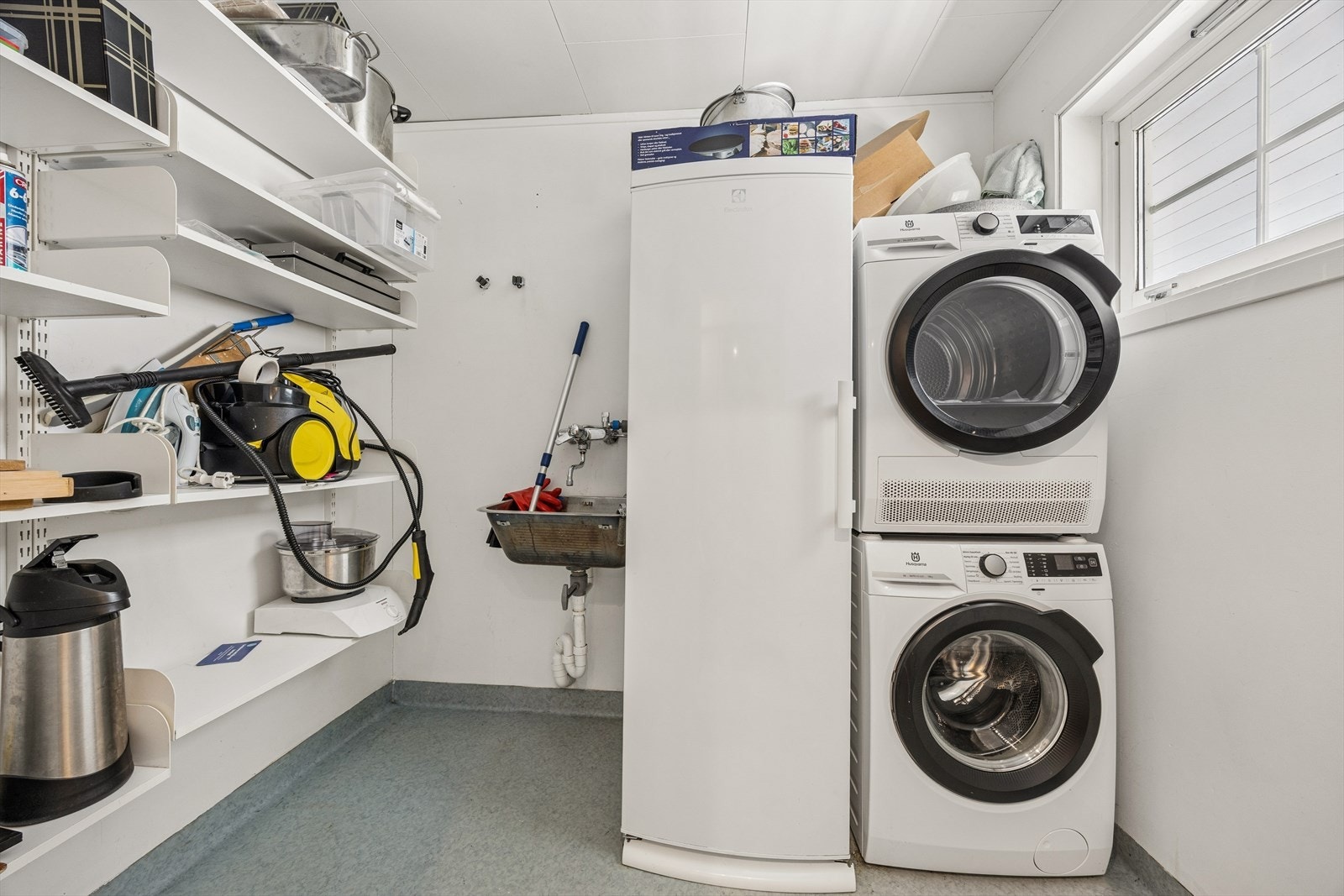 Praktisk vaskerom med opplegg for vaskemaskin, utslagsvask og gode hyllesystemer. Galleribilde