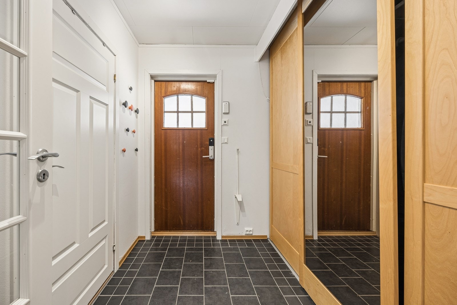 Du ønskes velkommen inn i en lys entré med flislagt gulv og god plass til oppbevaring av yttertøy i skyvedørsgarderobe. Galleribilde