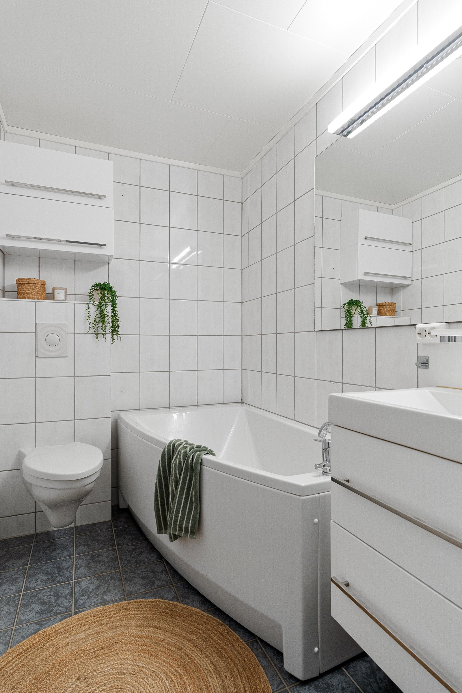 Flislagt bad/wc i 1. etasje med gulvvarme og badekar, som gir ekstra komfort og velvære for både store og små. Galleribilde