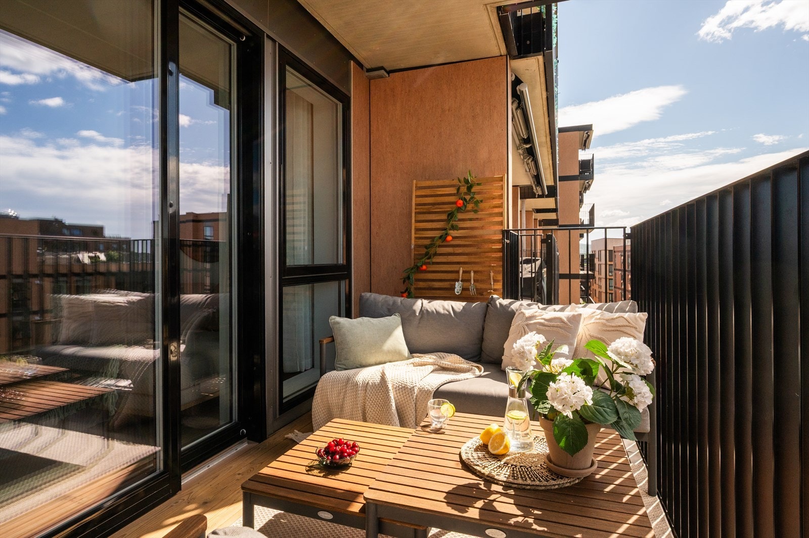 Balkongen har et lunt hjørne med plass sofa og kaffebord - perfekt for en bok i solen. Galleribilde