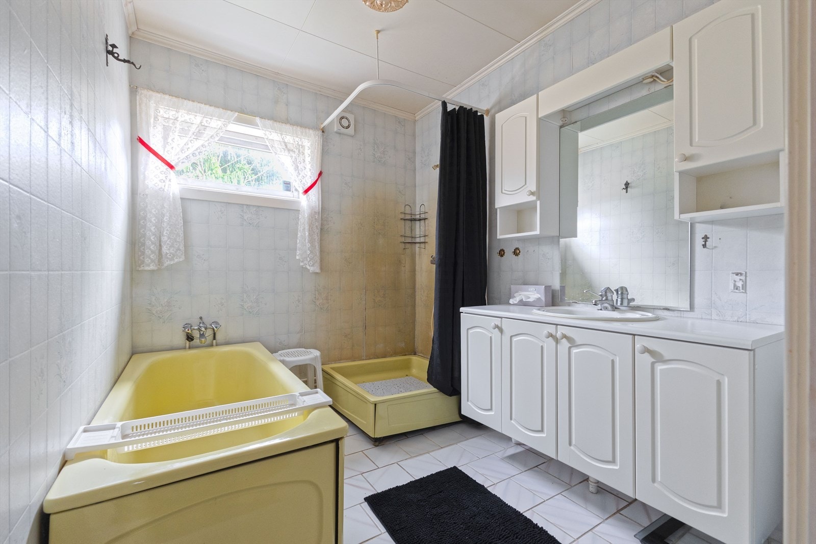 Badet er utstyrt med badekar, dusjhjørne med forheng og servantinnredning. Galleribilde