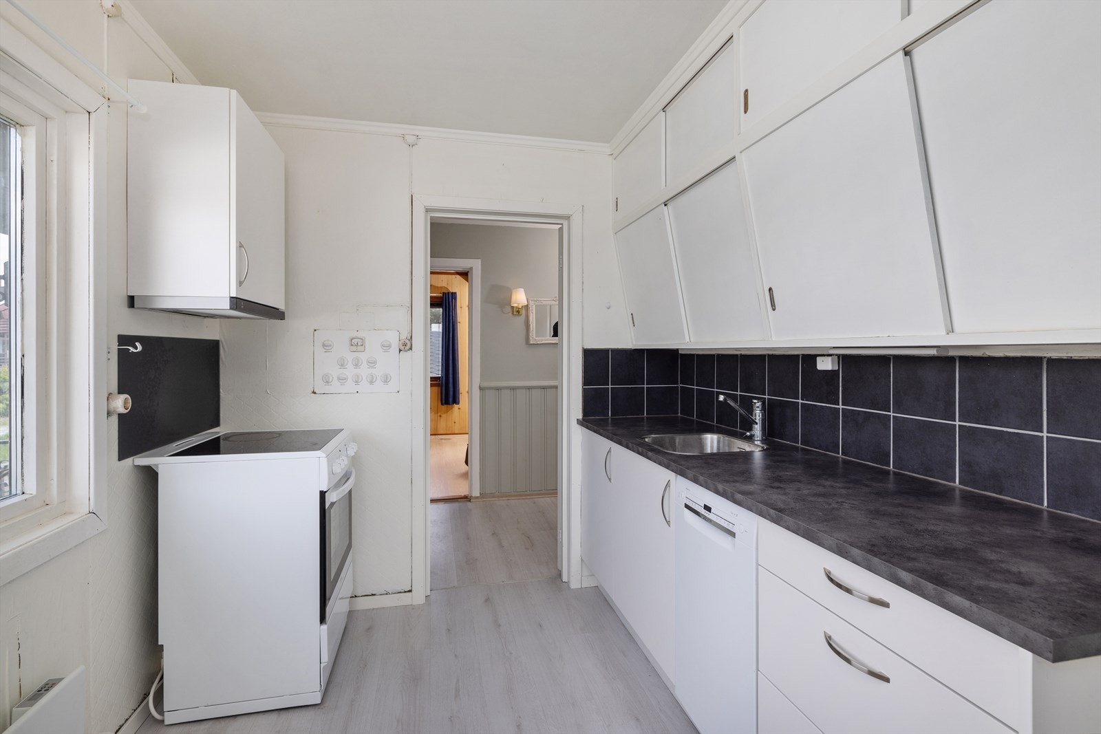 Kjøkkenet har en praktisk innredning med glatte fronter, laminatbenkeplate og er tilrettelagt for frittstående hvitevarer. Galleribilde