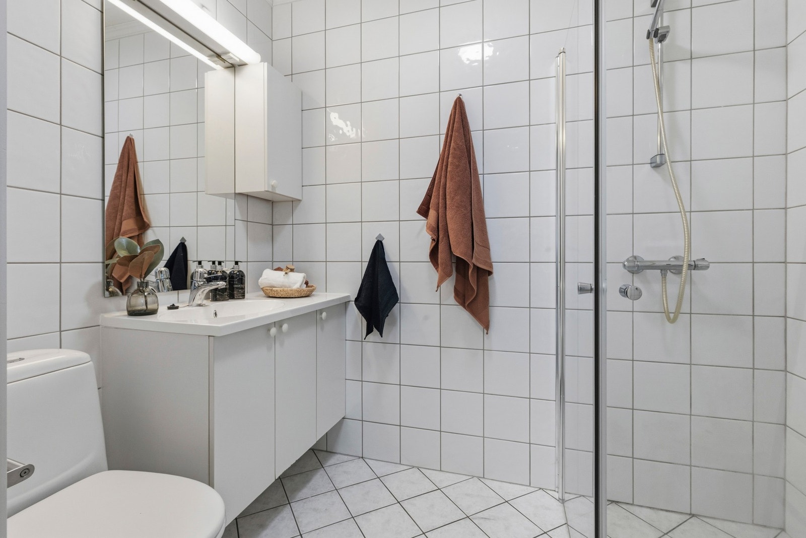 Badet har flislagte flater på gulv og vegger, og opplegg for vaskemaskin. Galleribilde