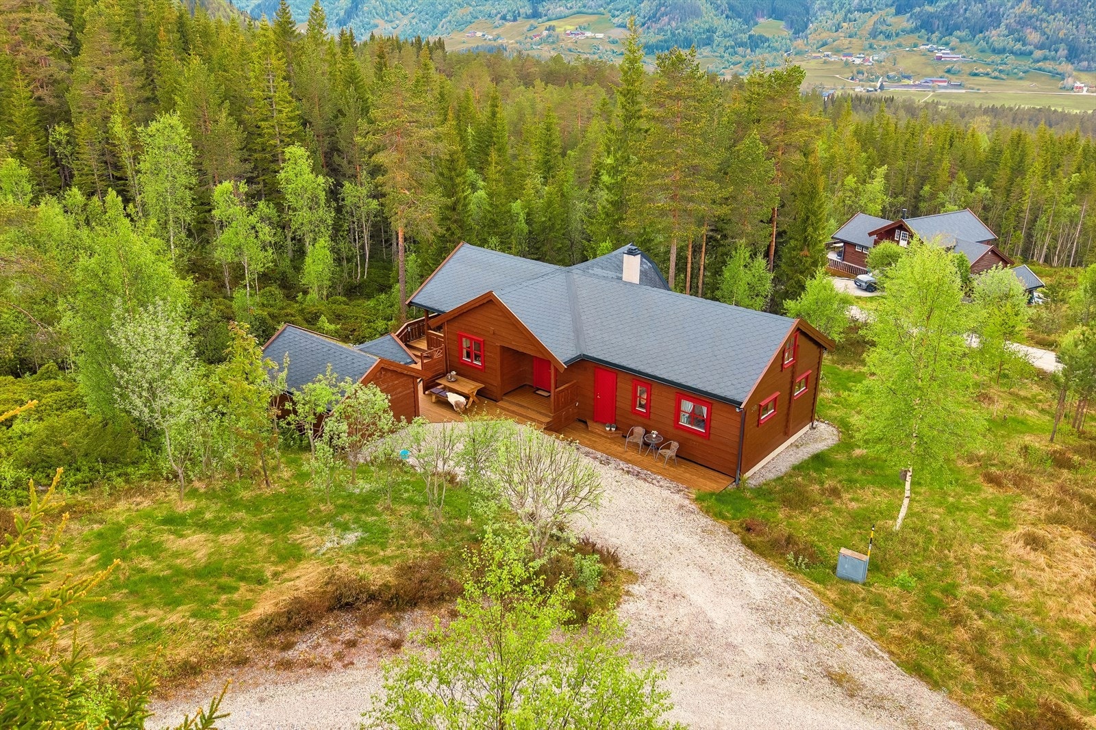 Tunet er fint opparbeidet med gruset innkjørsel/parkering, terrasser på ca. 50 m², en romslig utebod og steinheller Galleribilde