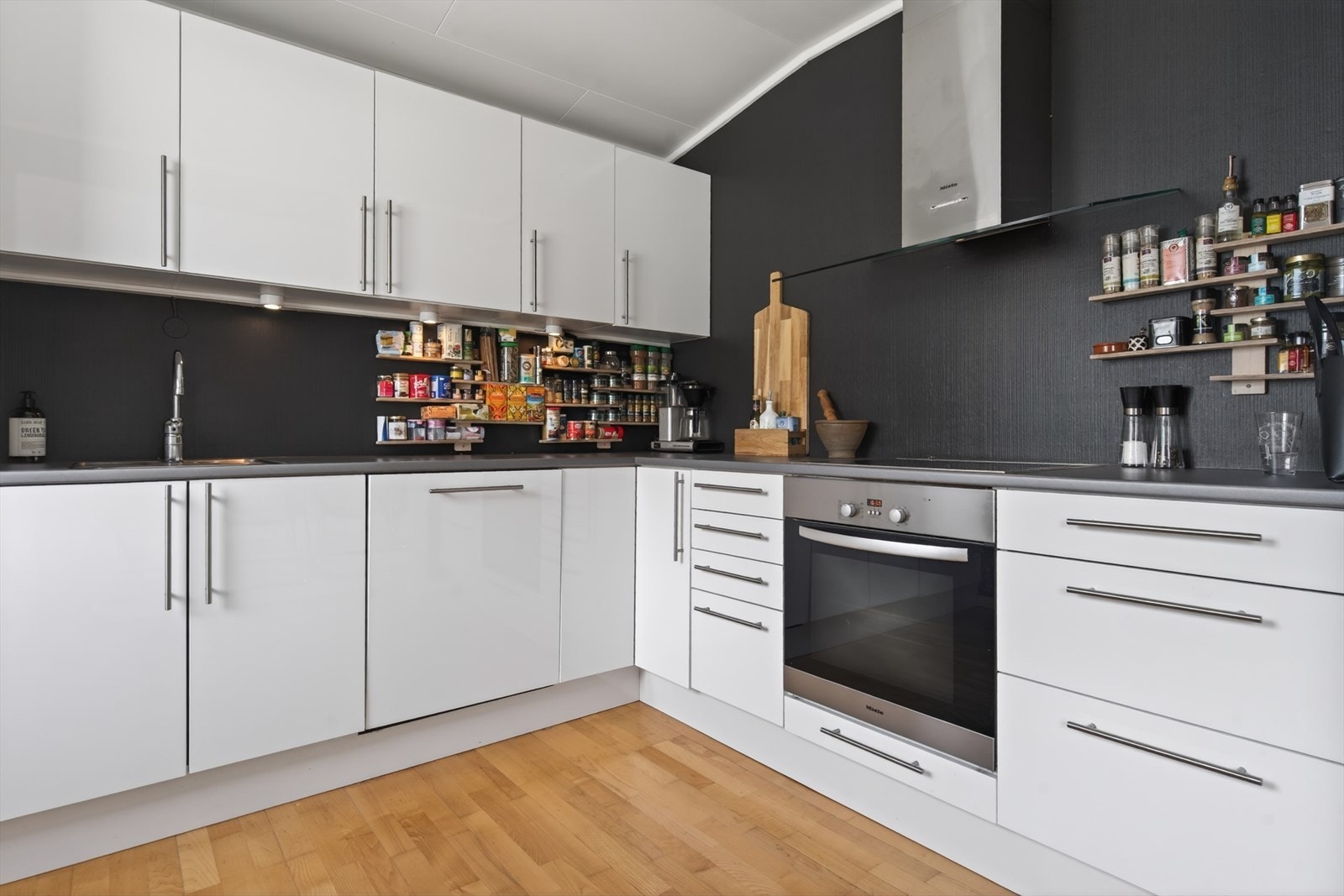 Moderne kjøkken med stilrent design, praktisk oppbevaring og integrerte hvitevarer. Perfekt for matlaging og sosiale sammenkomster. Galleribilde