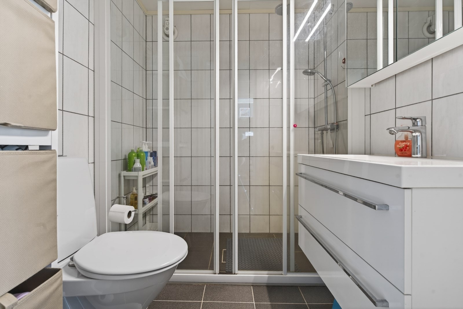 Moderne bad med romslig dusjnisje, stilrene fliser og praktisk innredning som gir en følelse av komfort og eleganse. Galleribilde