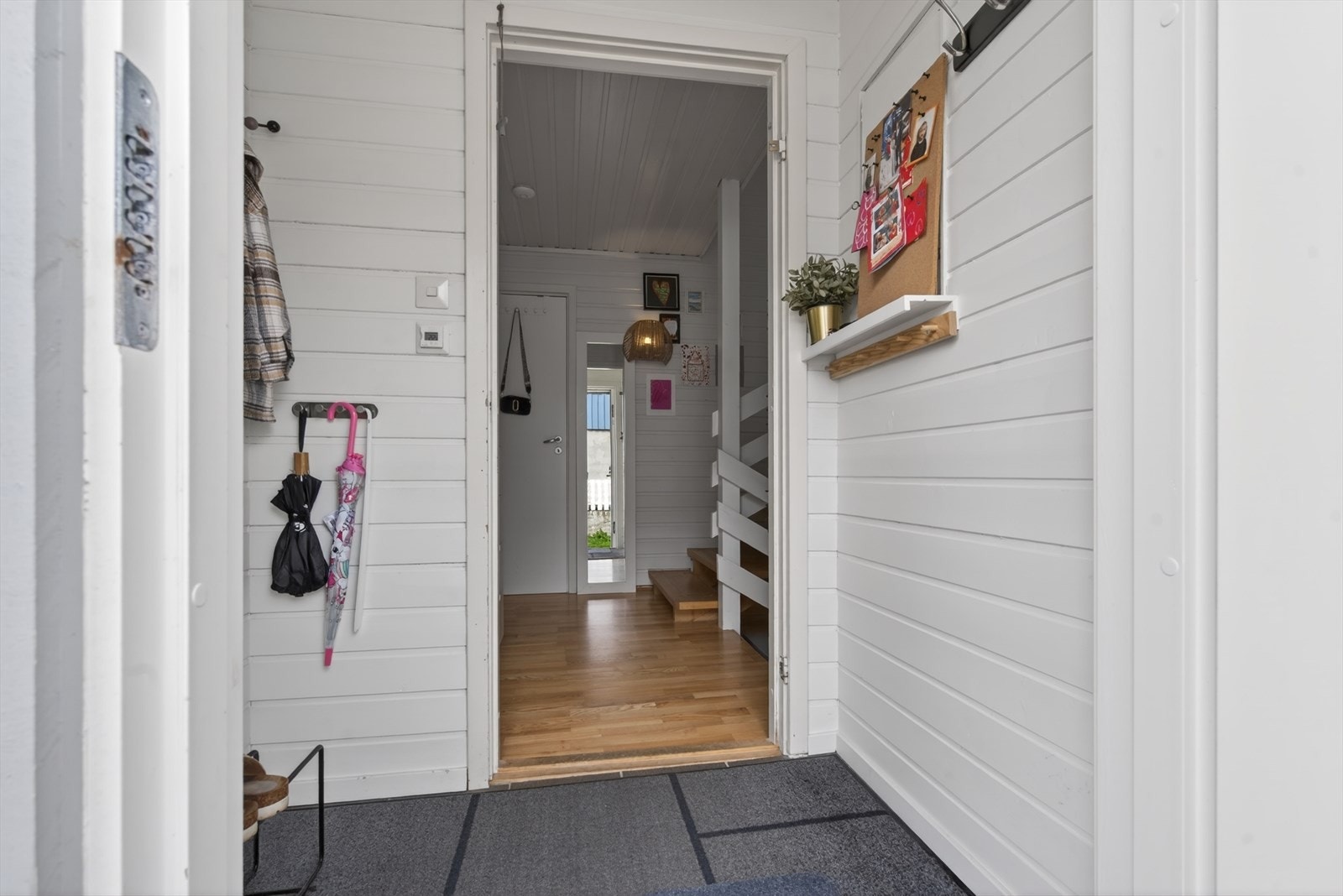 Innbydende entré med lyse panelvegger og praktisk oppbevaringsplass Galleribilde