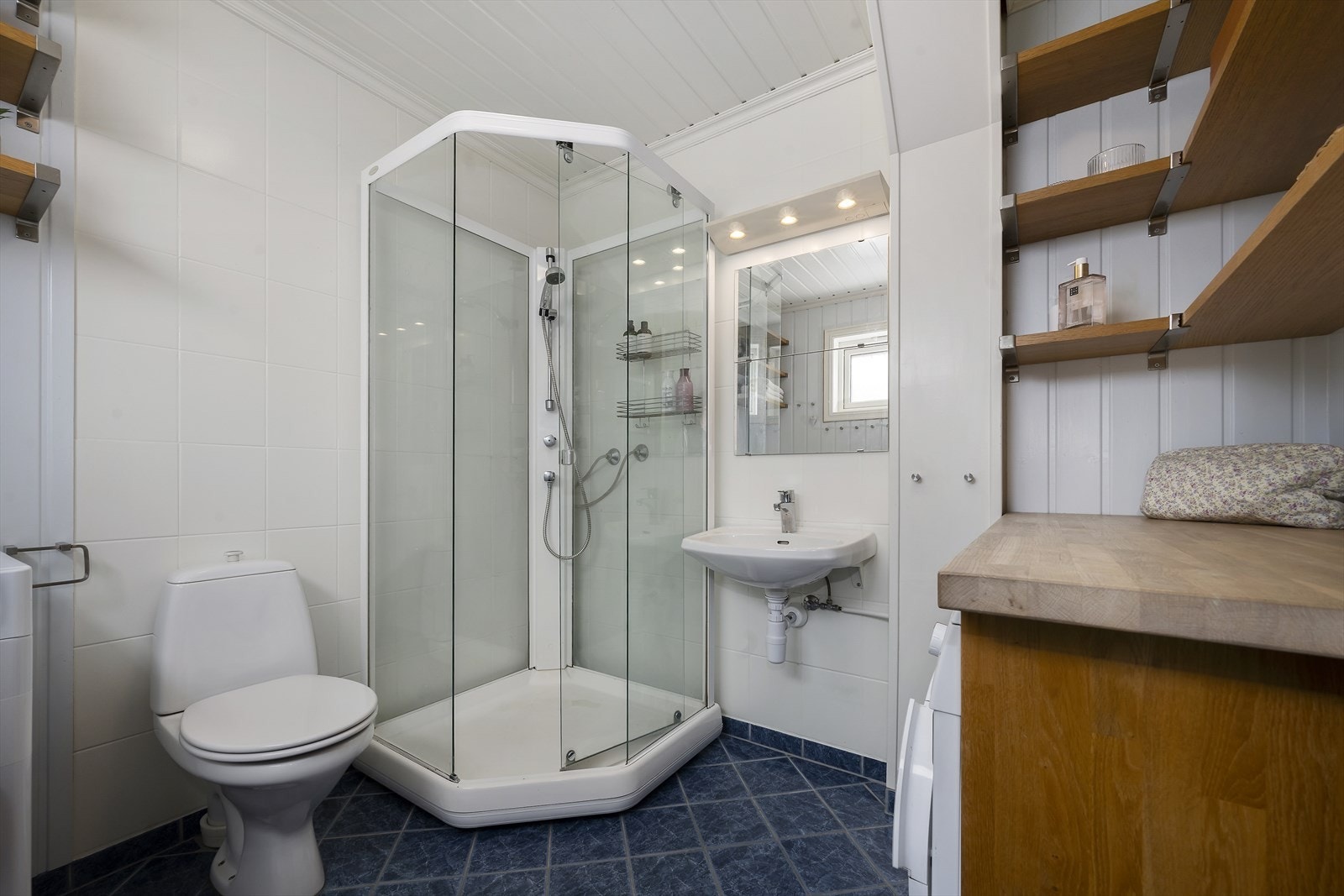 Badet i 1. etasje har flislagt gulv m/varmekabler og er utstyrt med servant, toalett, dusjkabinett og opplegg for vaskemaskin. Galleribilde