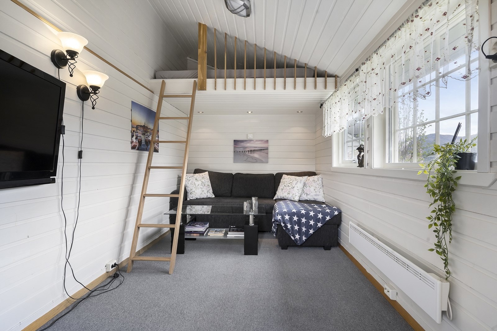 Tilbygget til garasjen er innredet som et oppholdsrom og har hemsløsning. Galleribilde