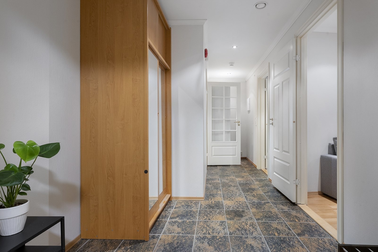 Entréen har flislagt golv med varmekablar og skyvedørsgarderobe. Galleribilde
