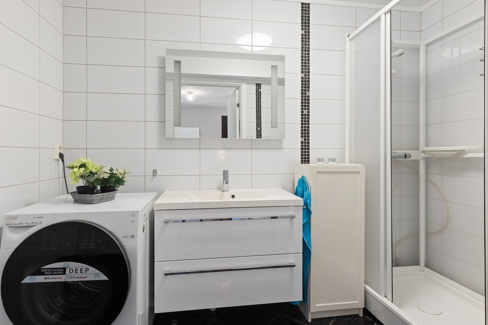 Flislagt bad med elektriske varmekabler i gulvet og opplegg for vaskemaskin. Galleribilde
