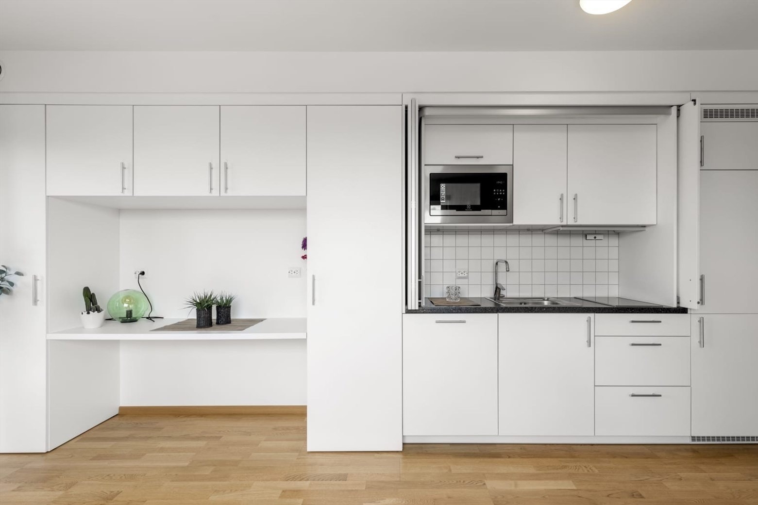 Leiligheten er designet for optimal arealbruk, med smarte, integrerte løsninger for både kjøkken og arbeidsplass. Galleribilde