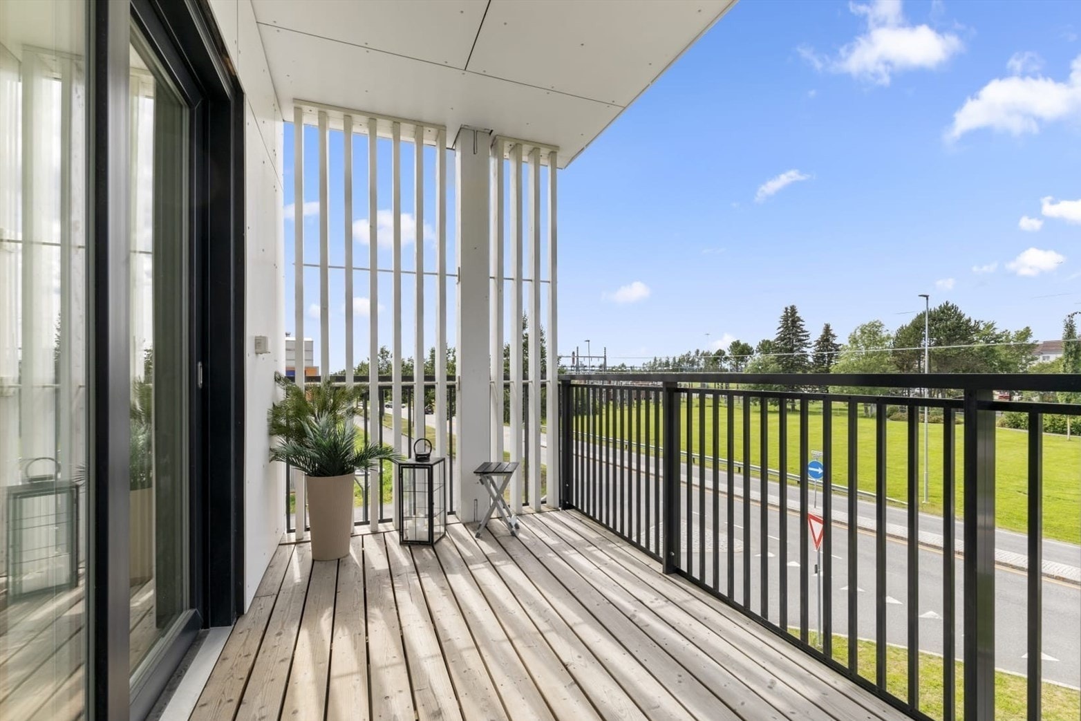 Balkongen er belagt med terrassebord i tre og har et rekkverk i stål. Galleribilde