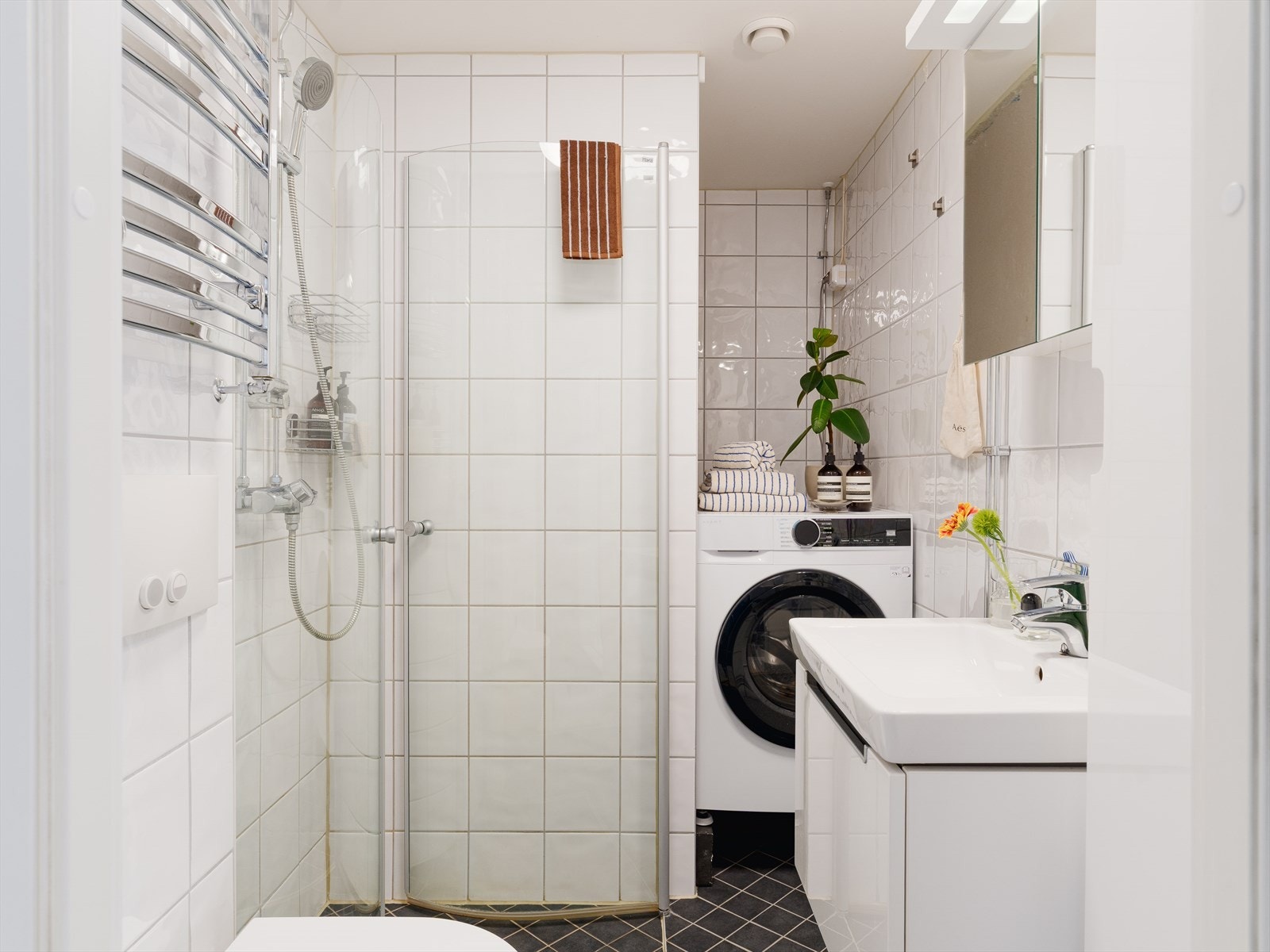 Leiligheten har et lyst og moderne baderom som ble pusset opp i regi av aksjelaget i 2013. Baderommet har mørke fliser på gulv med gulvvarme og hvite fliser på veggene. Galleribilde