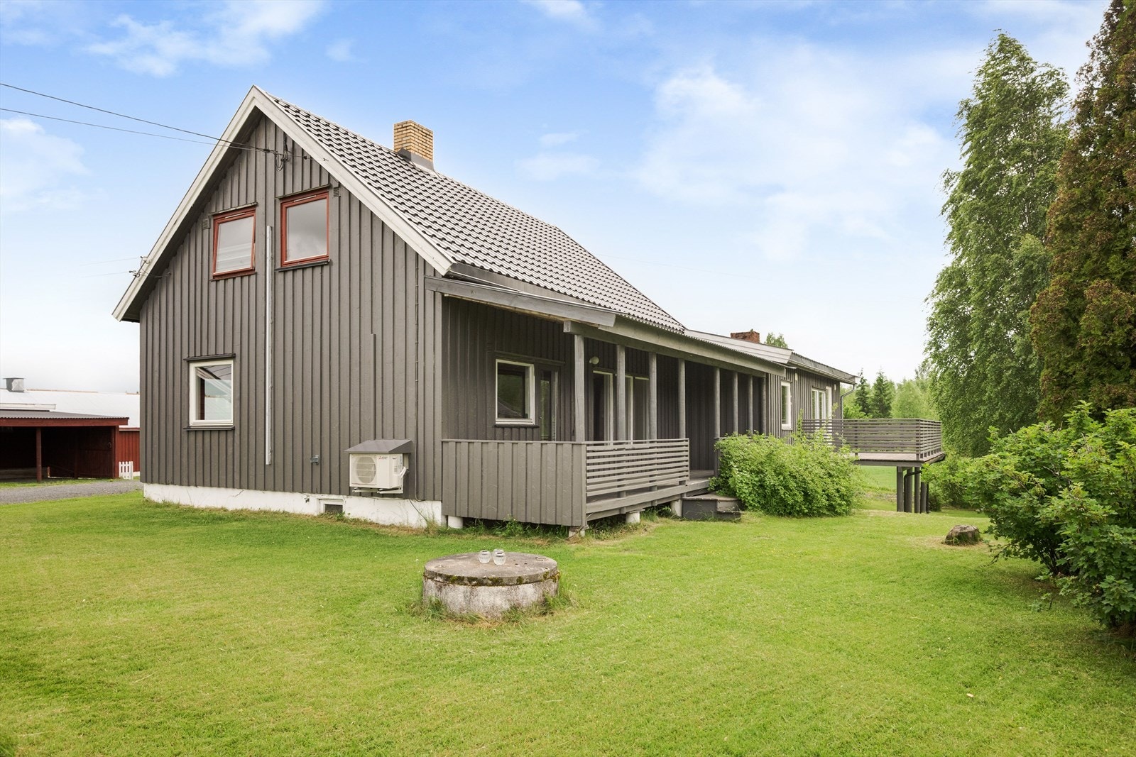 Pent opparbeidet tomt med plen og diverse beplantning. Galleribilde
