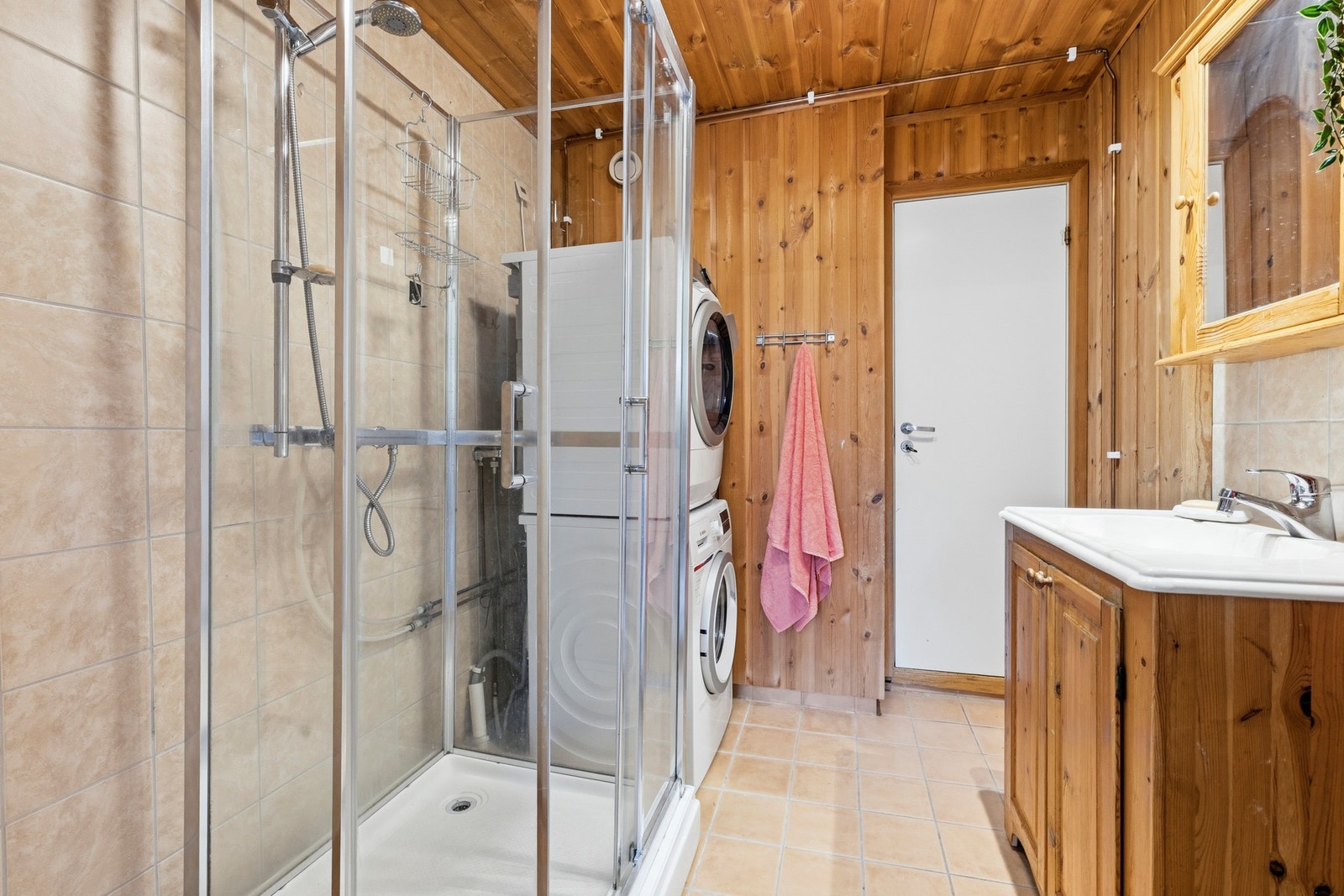 Badet har gulvstående servantskap og dusjkabinett. Galleribilde