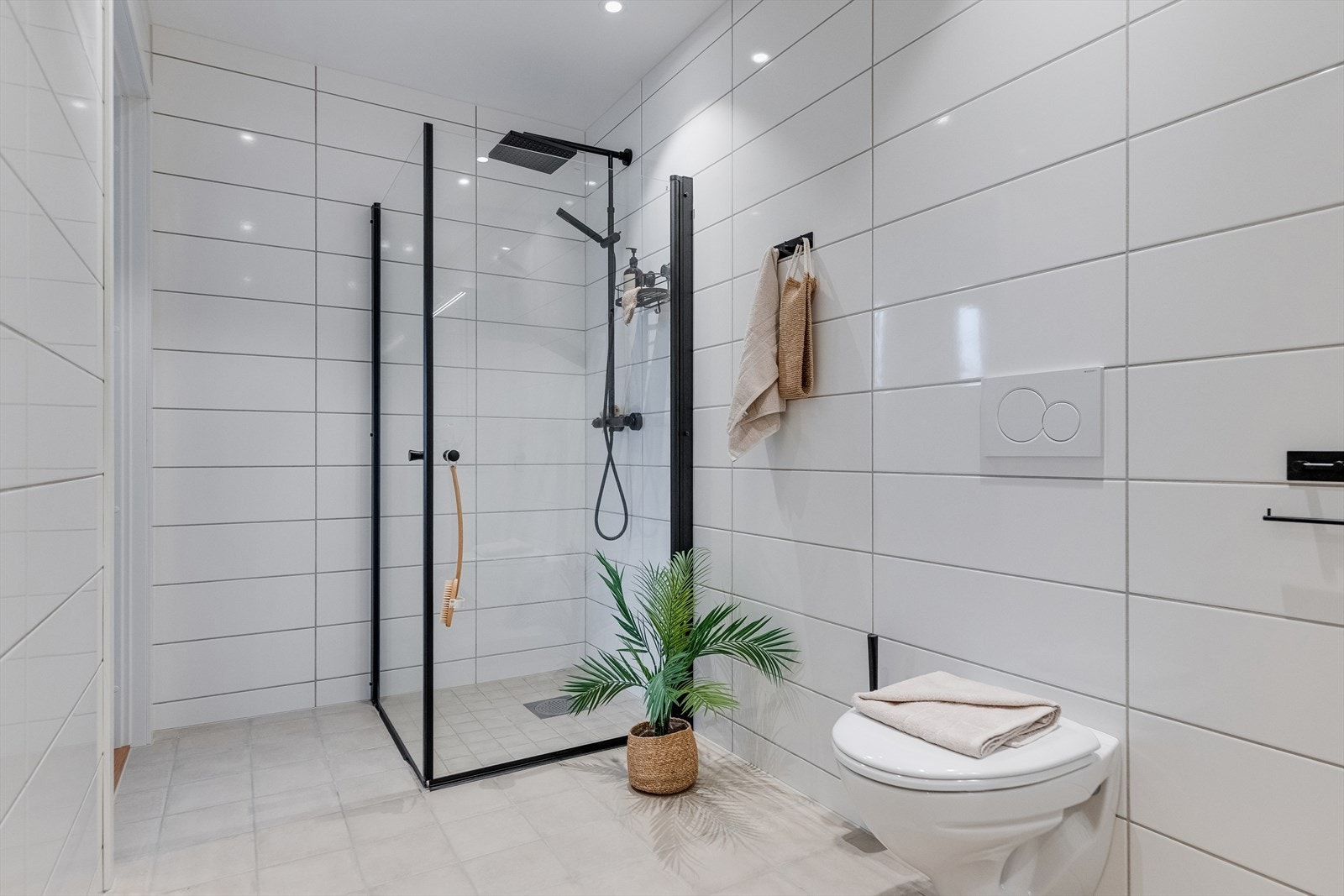 Badet er lekkert og helfliset med moderne innredning, varmekabler i gulv og spottbelysning i tak. Galleribilde