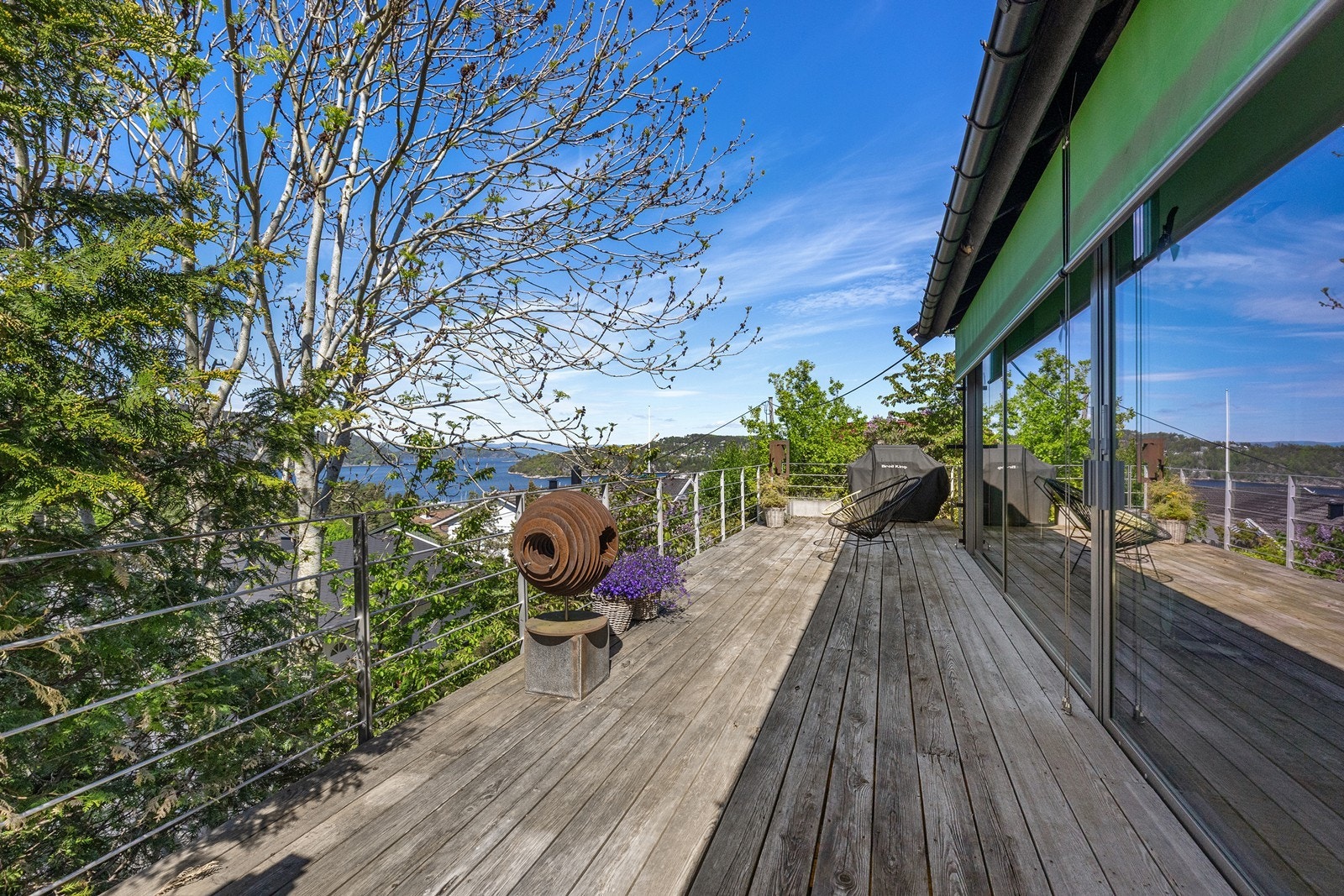Stor vestvendt terrasse med flotte solforhold og skyvedører ut fra stuen. Galleribilde
