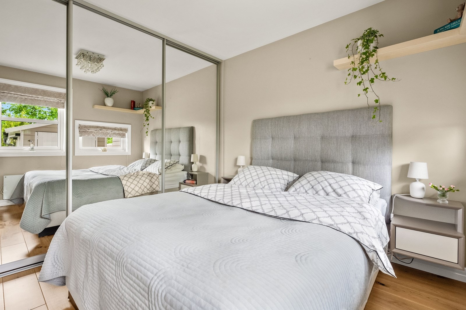Romslig og rolig soverom med 1-stavs eikeparkett på gulv og skyvedørsgarderobe Galleribilde