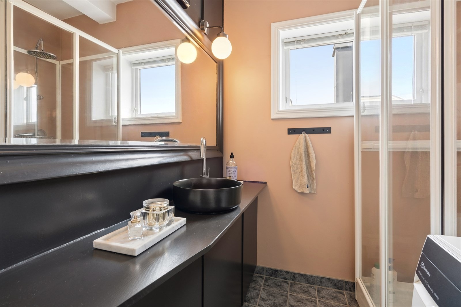 Badet har en heldekkende innredning med servantbolle og stort speil. Galleribilde