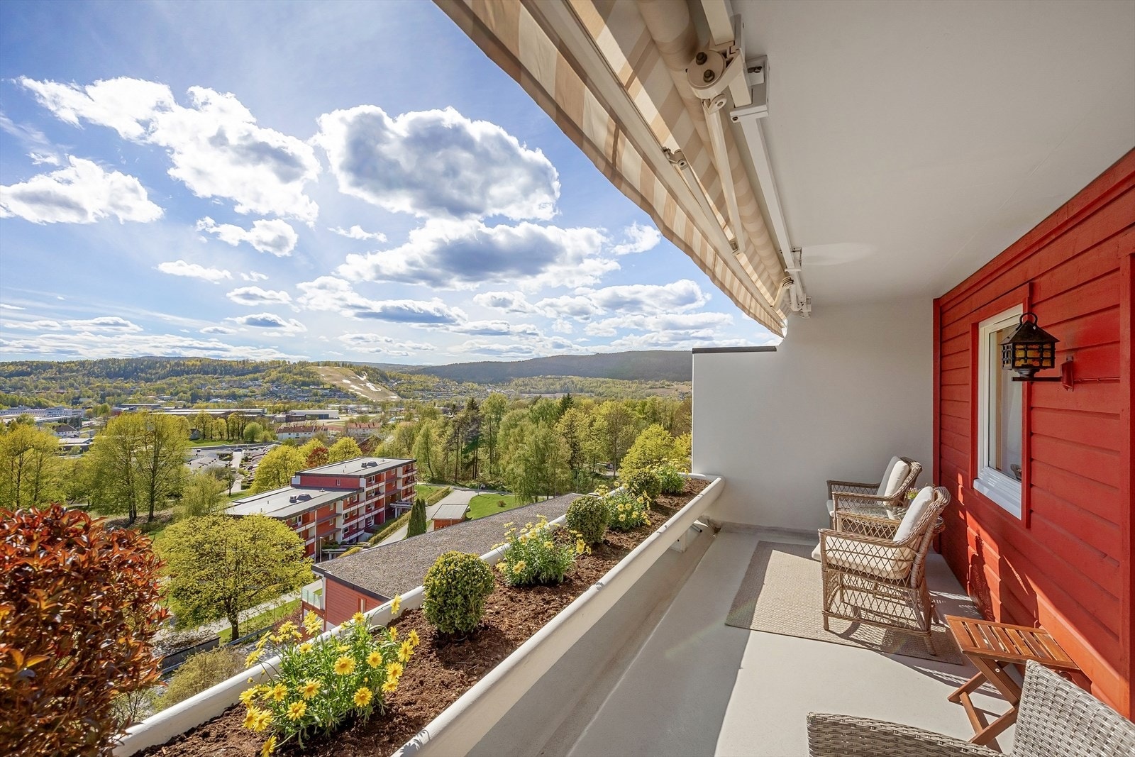 Fra stuen er det direkte utgang til en flott og solrik terrasse på 11 m² med utebod og blomsterbed Galleribilde