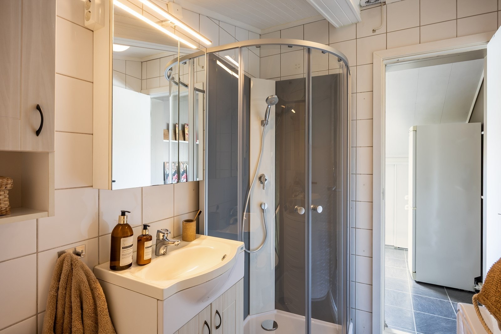 Innenfor badet er det et lite skap som praktisk kan benyttes til lagring. Galleribilde