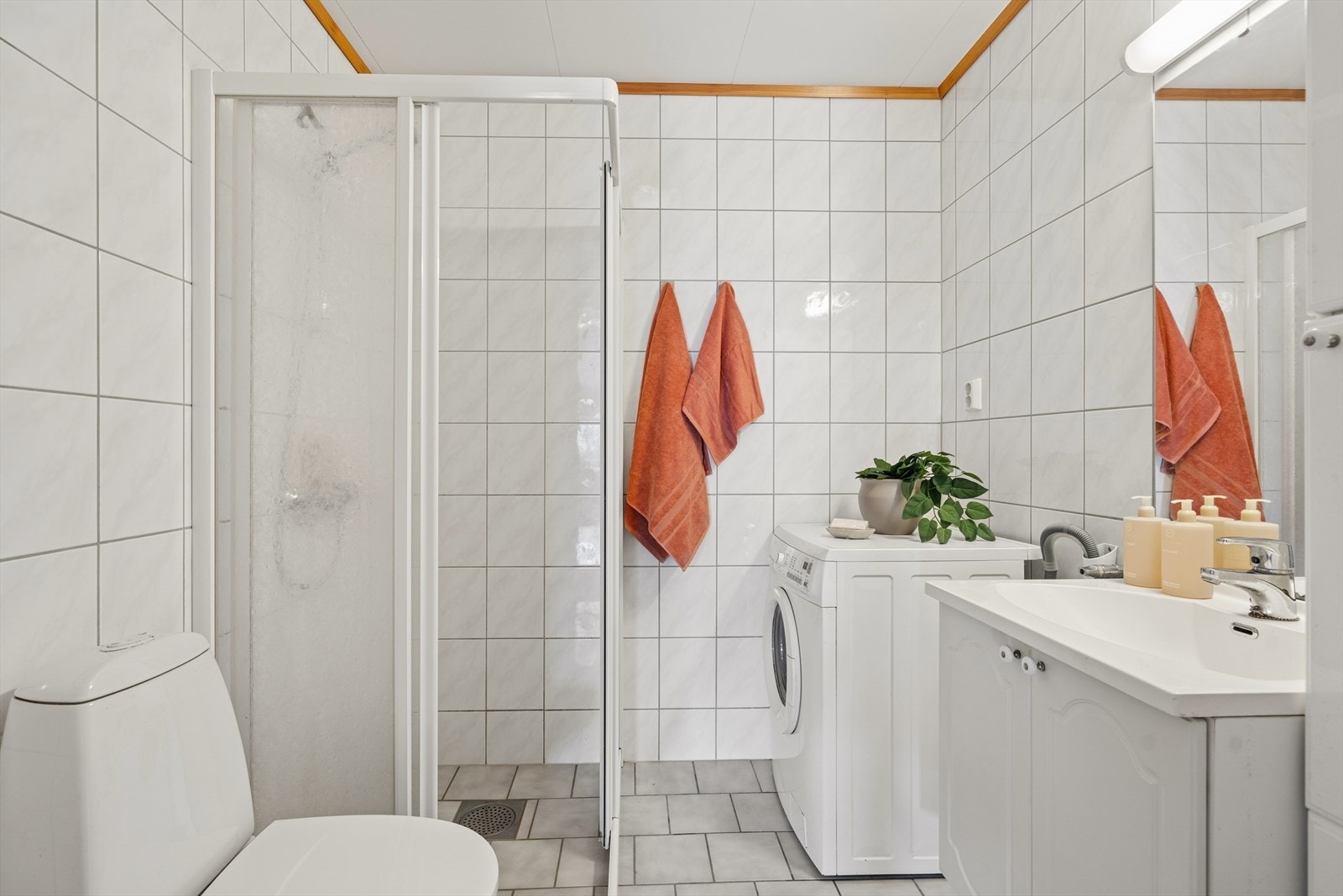 Badet har opplegg for vaskemaskin, servantinnredning og dusjhjørne. Galleribilde