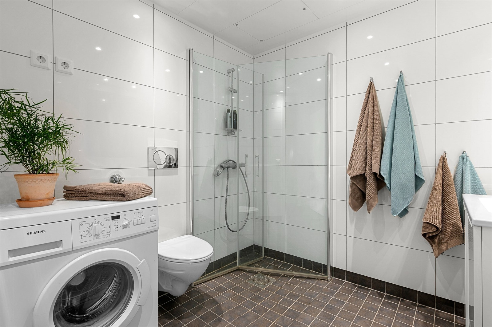 Badet er innredet med servantskap med speil og sideskap, dusjhjørne og vegghengt toalett . Galleribilde