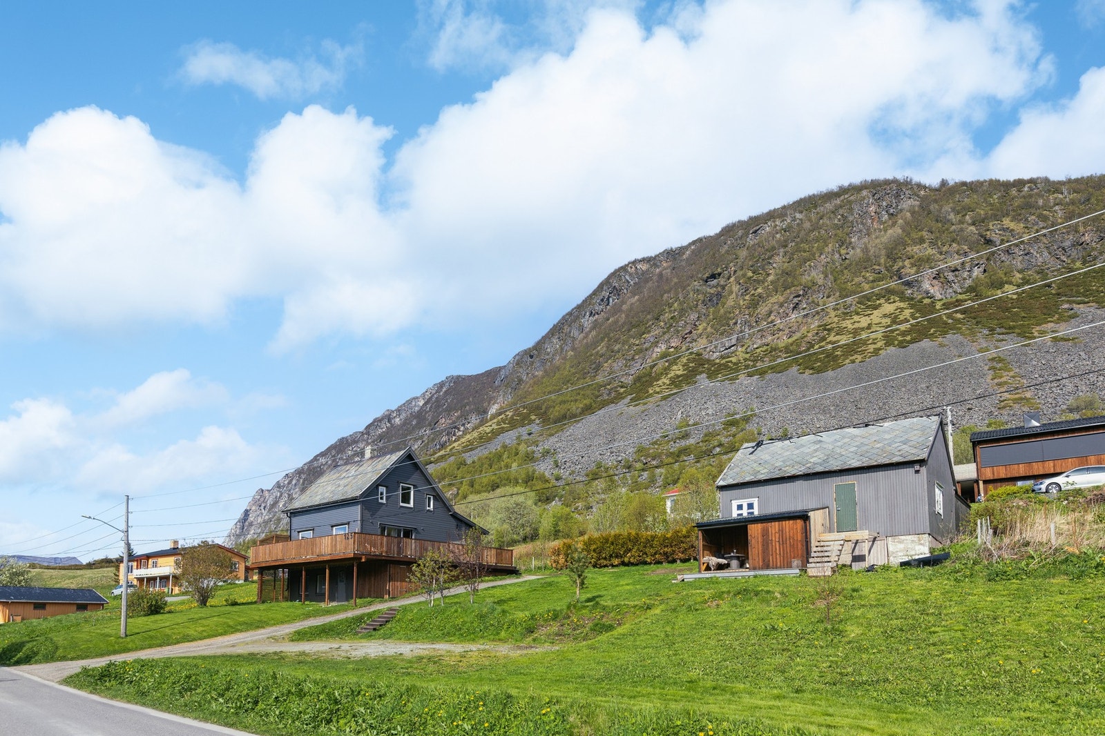 Enebolig med stor, omkransende terrasse og et separat uthus/fjøs med carport. Eiendommen ligger fritt til med utsikt mot fjorden Galleribilde