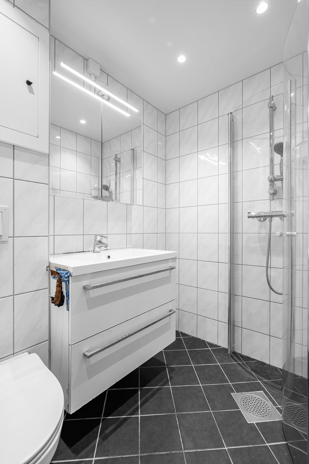 Bad er renovert i regi av borettslaget. Rommet har innredning med nedfelt servant, speilskap med belysning, veggmontert toalett og innfellbare dusjvegger/hjørne i herdet glass. Galleribilde