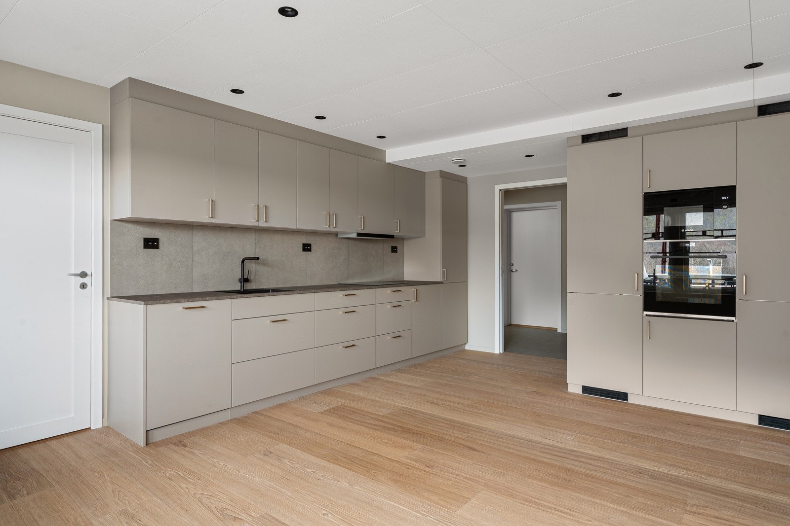 Det er integrerte hvitevarer i arbeidshøyde og doble skap (et for kjøl og et for frys). Benkeplate av kompaktlaminat gir en robust og solid følelse. Platen er i tillegg enkel å rengjøre samt tåler opptil 110 varmegrader. Galleribilde