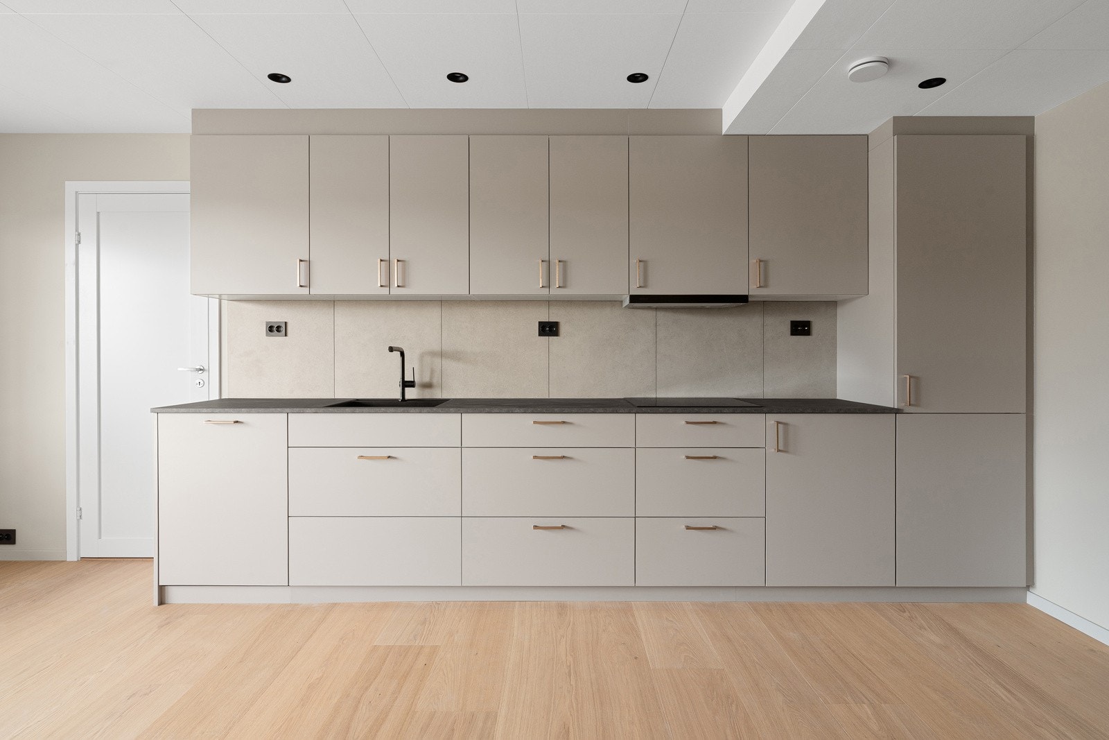 Kjøkkenet, fra danske Kvik, har rikelig med lagringsplass i over- og underskap, fliser er brukt som backsplash på vegg under skap. Galleribilde